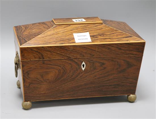 A Regency rosewood sarcophagus shaped tea caddy, the lifting top enclosing two covered compartments, width 32cm